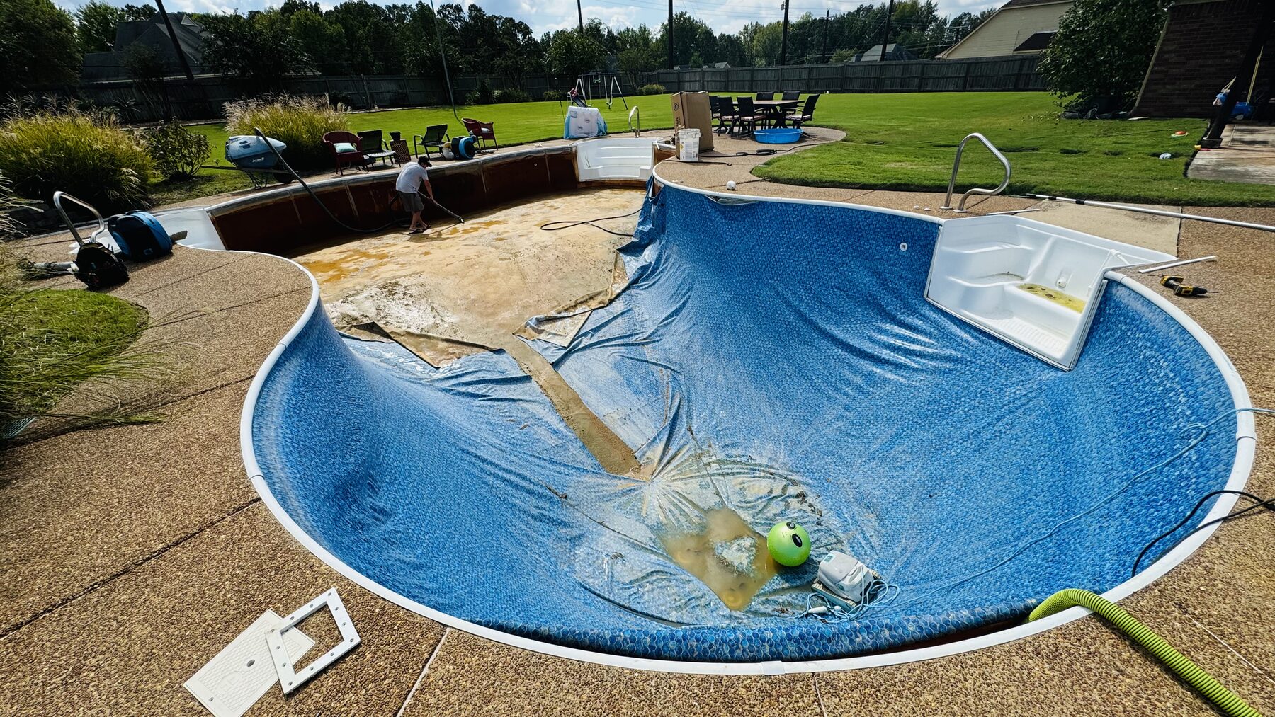 Freeform pool with a worn liner and little water